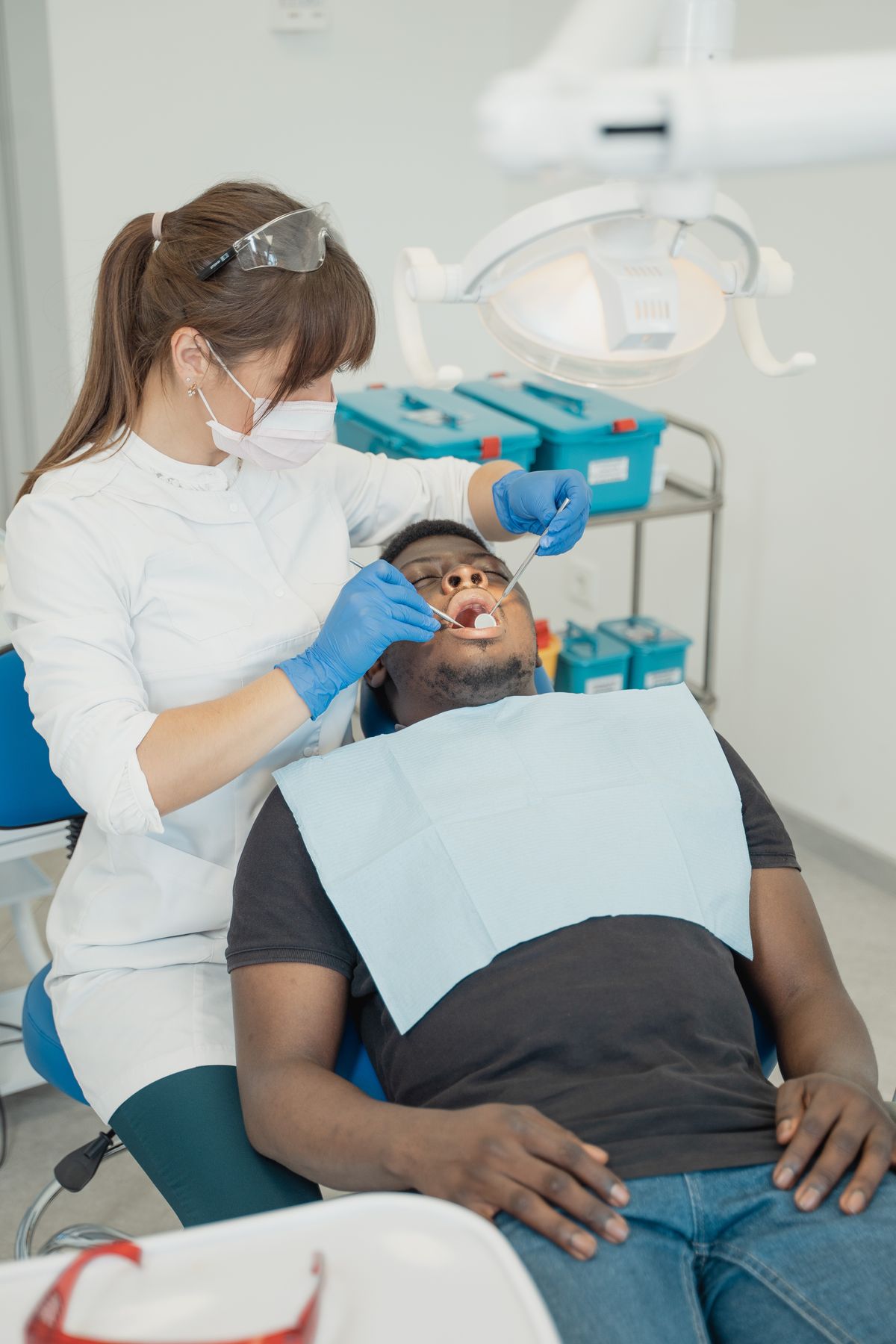 A gentle dentist examining a relaxed, smiling patient in a bright modern dental clinic