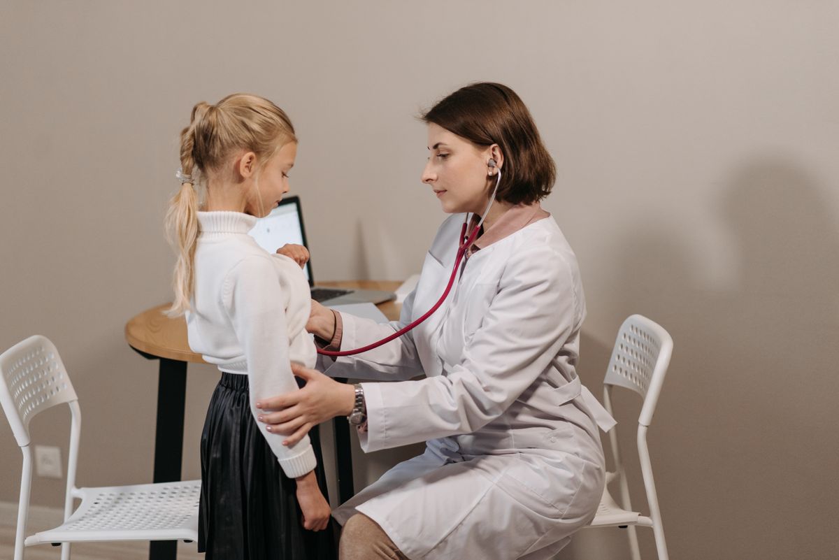 A gentle pediatrician examining a young child during a check-up
